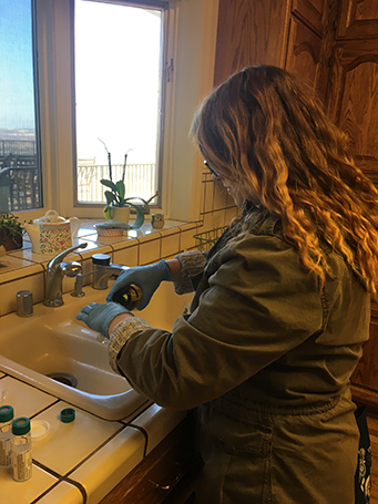 woman researcher testing samples at a kitchen sink