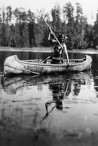 “Ojibwe Fisherman” in a canoe preparing to spear a fish
