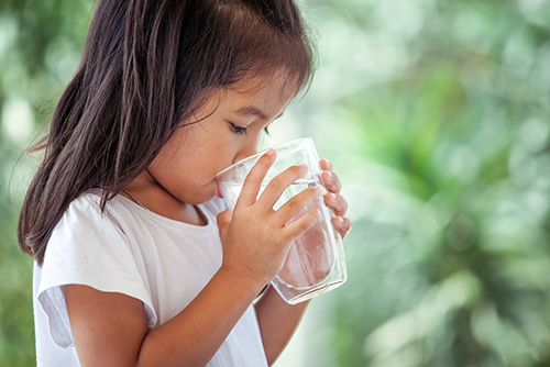 child drinking a glass of water