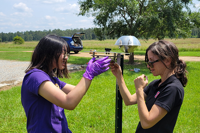 2 researchers adjusting outdoor equipment