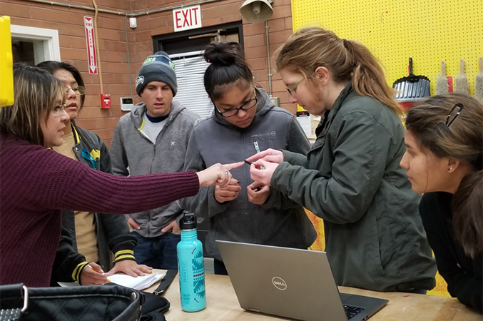 students gathered around a laptop