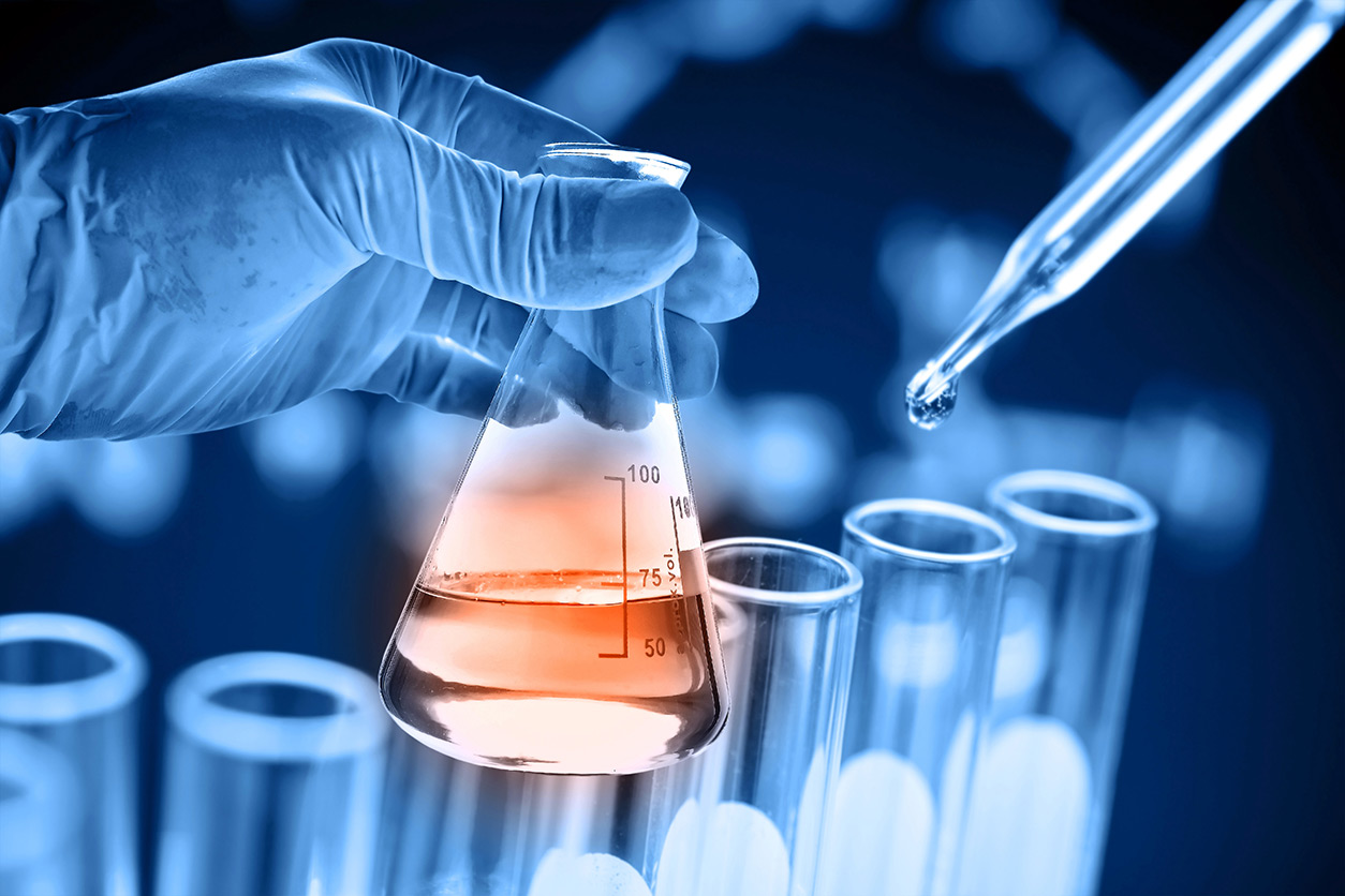 hand holding flask, dropper and test tubes