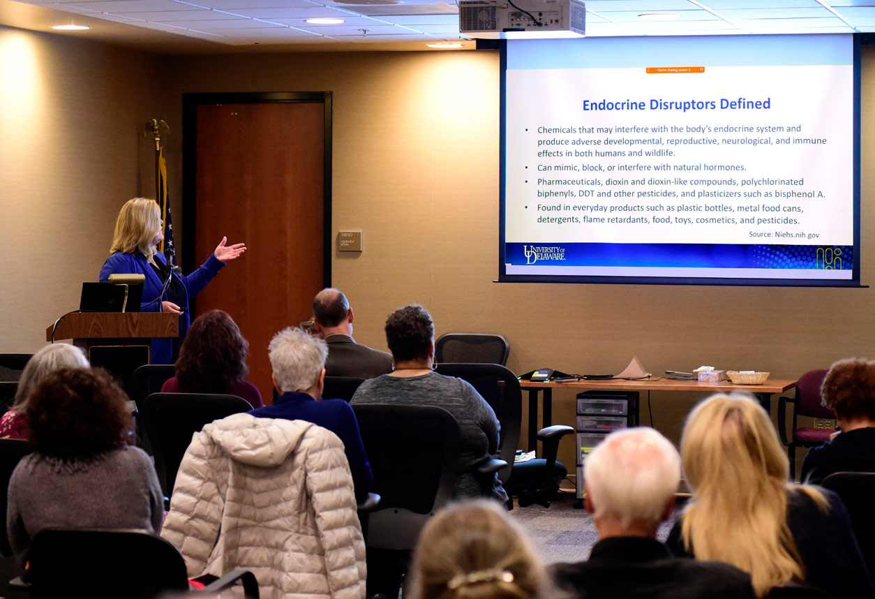 Kami Silk, Ph.D., in front of the audience, points at projection screen with Endocrine Disruptors Defined