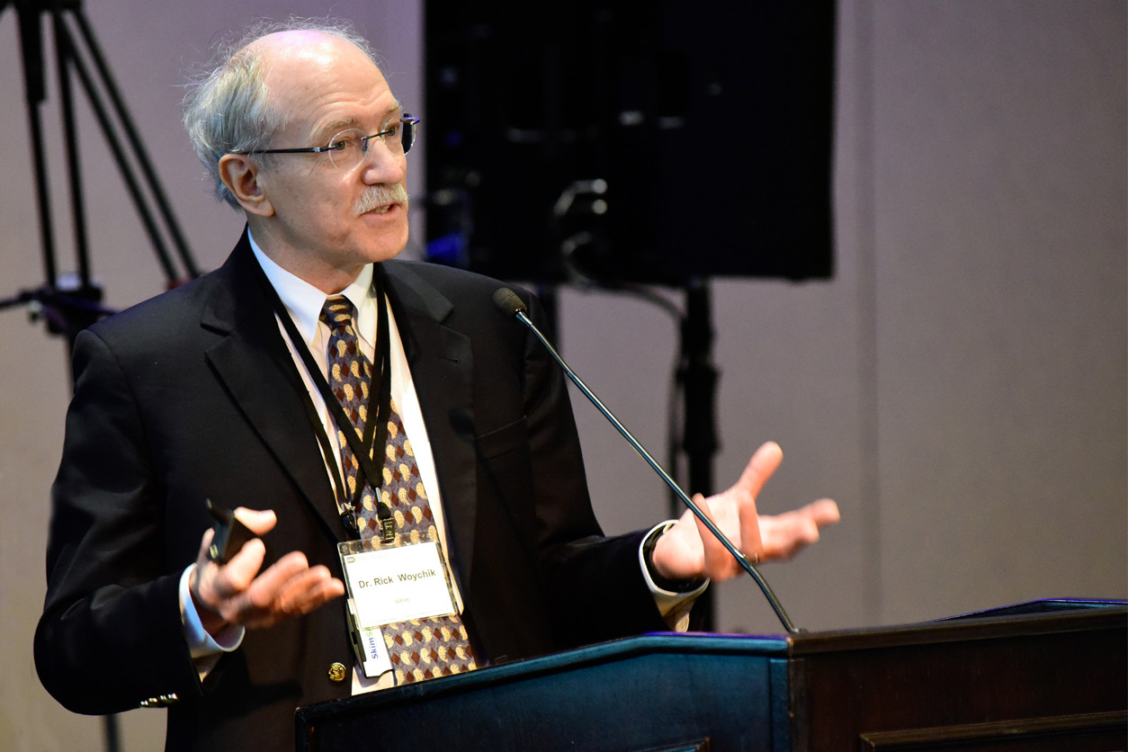 Rick Woychik, Ph.D. stands at podium