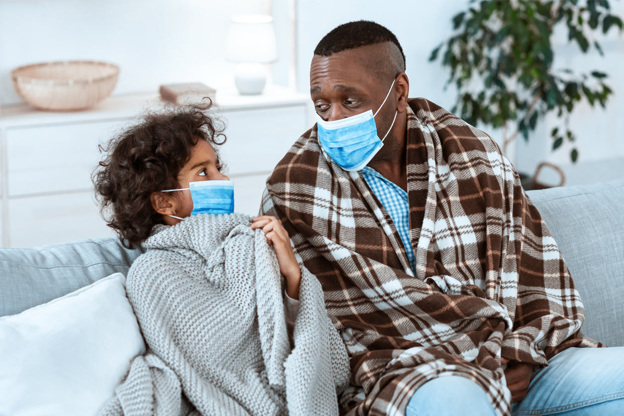 girl and a man wearing protective masks at home
