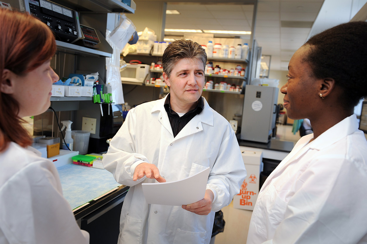 Matthew Breen, Ph.D. talking with two NCSU graduate students
