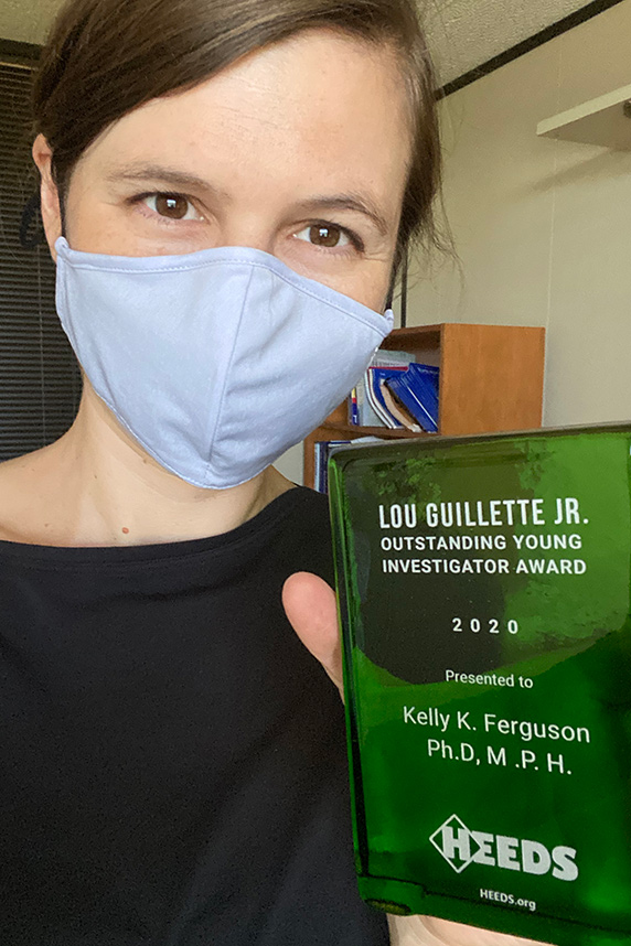 Kelly Ferguson, Ph.D. holds her Lou Guillette, Jr. Outstanding Young Investigator Award