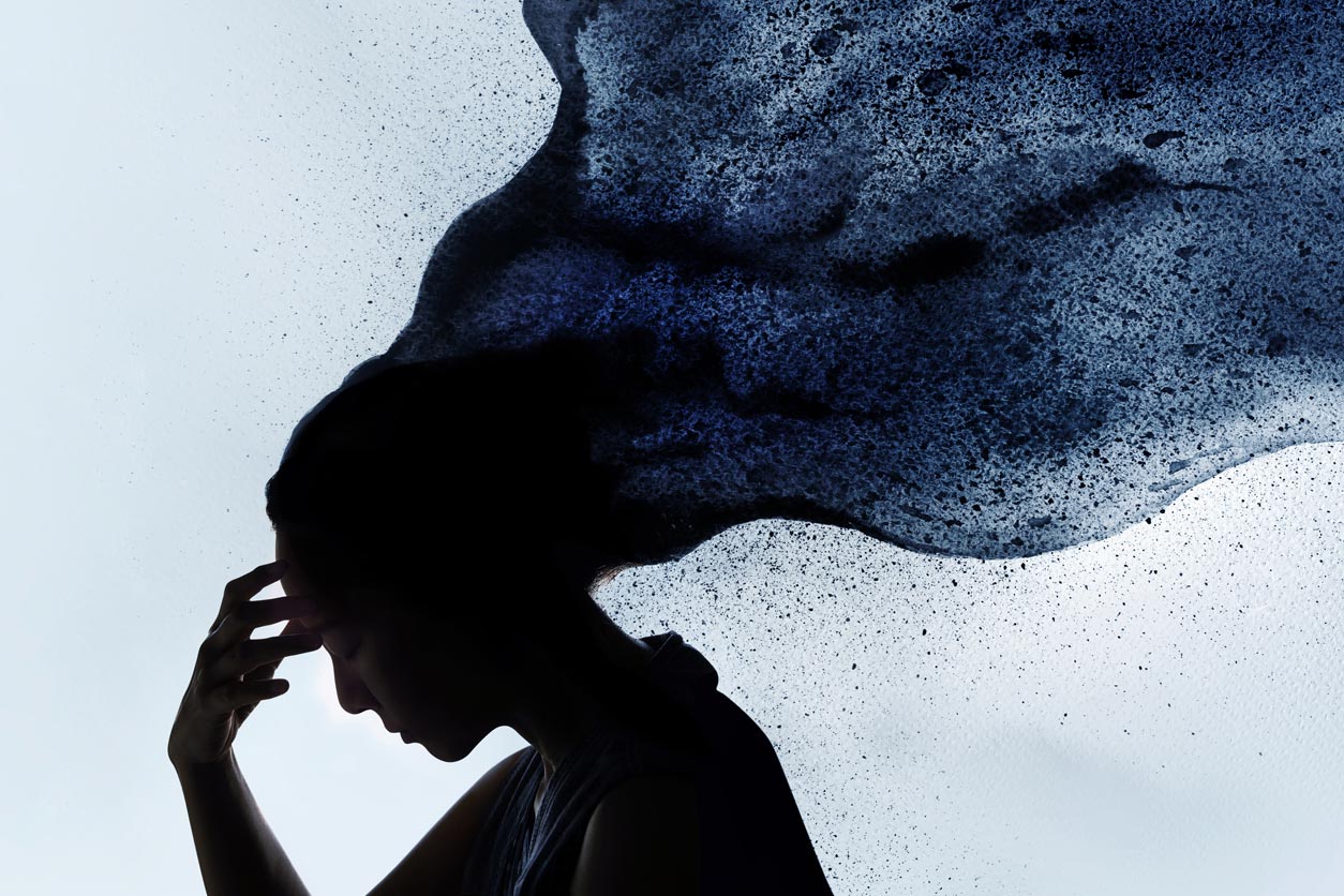 side profile of female with hand on head, looking down, billow of black smoke lifting from her hair