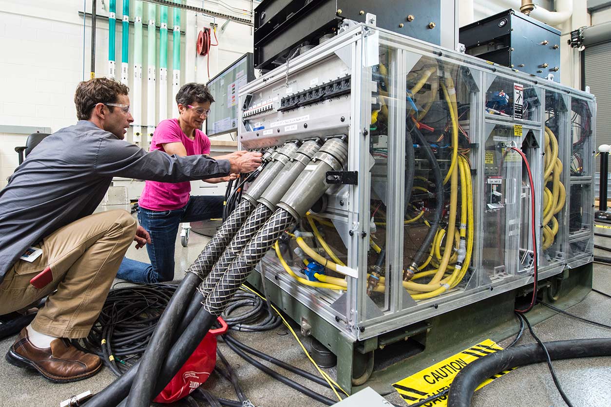 two people work on a Consolidated Utility Base Energy (CUBE) System