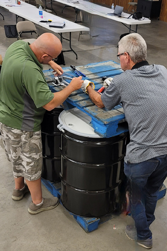 men transporting barrels of waste