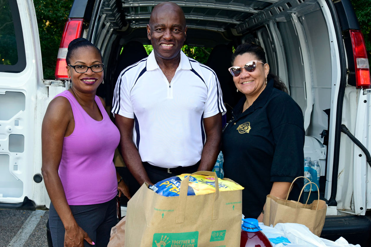 Monya Brace, Pinkney Wilder, and Edith Lee pose with donation bags