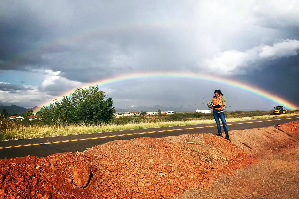 Anides Morales looks at transborder sewage overflows on the side of a road