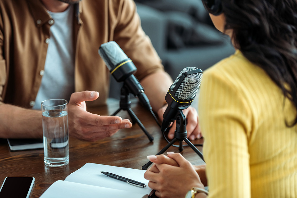 people sitting with two microphones on a table