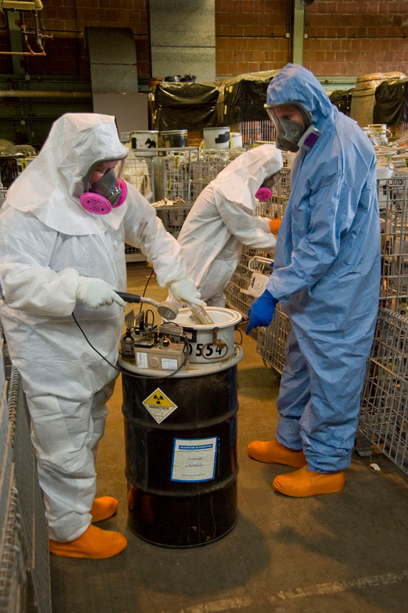 Workers in full safety suit and mask working with hazardous materials