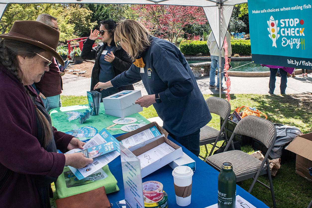 Attendees of the Go Fish Fest gather materials, including a calendar and wallet card.